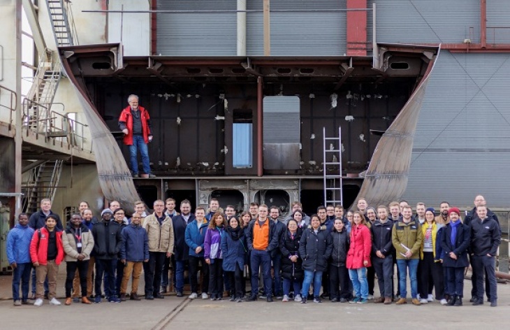 Participants on the excursion to the Hitzler shipyard in Lauenburg in front of part of the hull section of the Hereon research vessel Coriolis, which is currently under construction. This will also have a hydrogen energy system. Photo: DLR Inst. of Maritime Energy Systems / Jorgen Depken Photo Hitzler-Werft Lauenburg